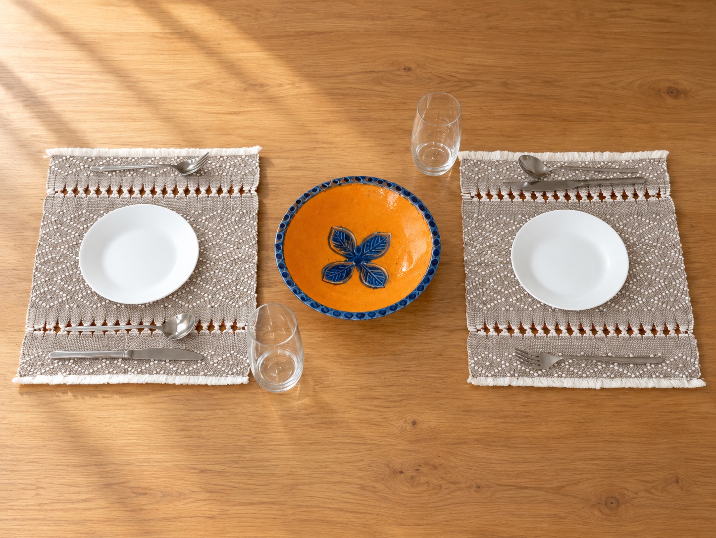 Dos individuales bordados de Dilia Suárez en una mesa de madera